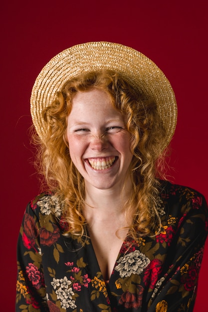 Free Photo redhead young woman with hat laughing at camera