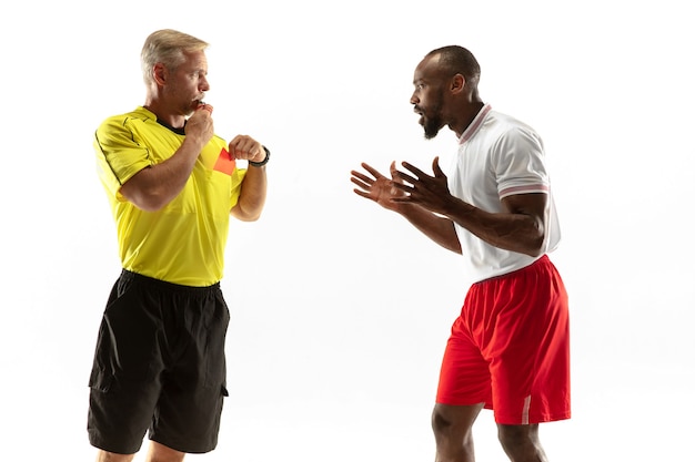 Referee showing a red card to a displeased african-american football or soccer player