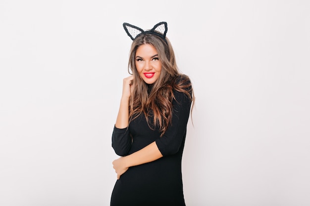 Refined slim woman in black dress looking to camera