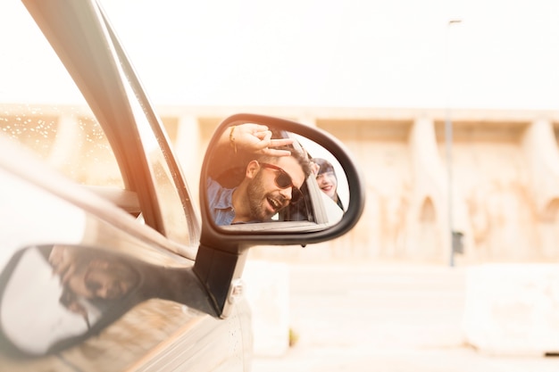 Free Photo reflection of couple in car side mirror