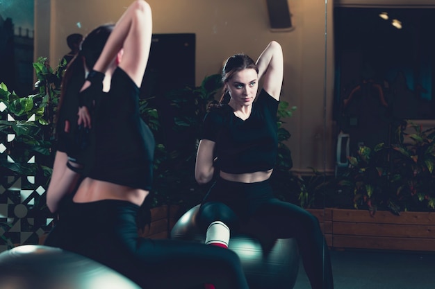 Reflection of exercising woman on mirror at gym