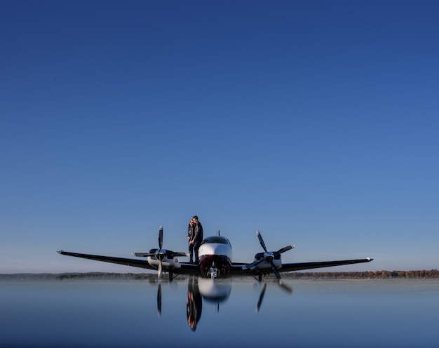 Free photo reflection of a helicopter and a couple in love and blue sky, romantic unforgotten date