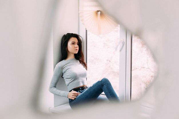 Reflection of lady on windowsill in the mirror