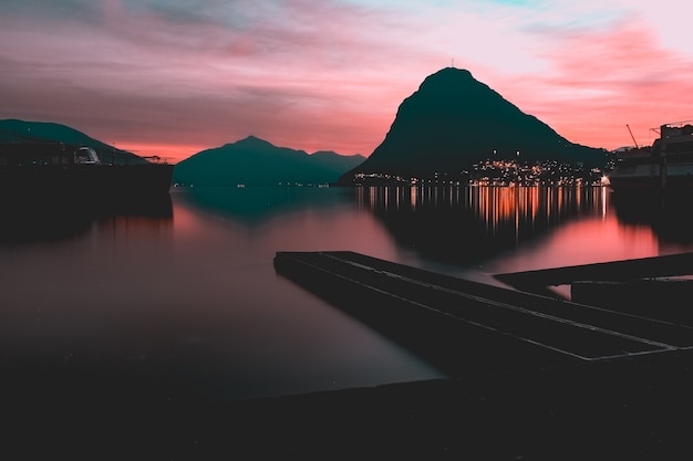 Free photo reflection of the lights and the mountain in a lake captured in parco ciani, lugano, switzerland