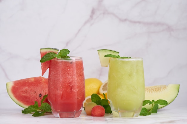 Refreshing summer citrus cocktail with lemon, watermelon and melon with mint and ice cubes in glass