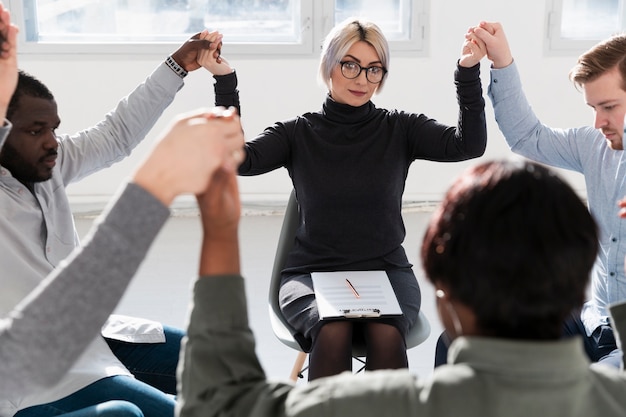 Free photo rehab doctor raising hands with patients