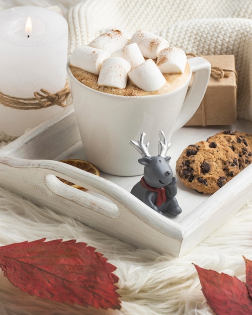 Free photo reindeer figurine with cup of hot cocoa and present on tray