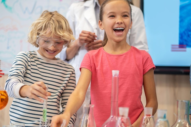 Rejoicing girl near table in chemistry class