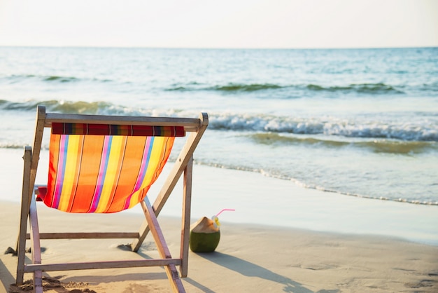 Relax beach chair with fresh coconut on clean sand beach with blue sea and clear sky - sea nature relax concept