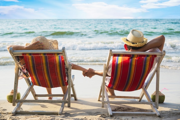 Free photo relax couple lay down on beach chiar with sea wave - man and woman have vacation at sea nature concept