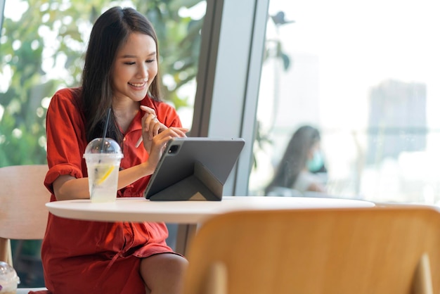 Relax leisure attractive smart asian female freelance entrepreneur smile and enjoy working with smartphone and laptop at cafe with blur city business digital nomad casual ideas concept