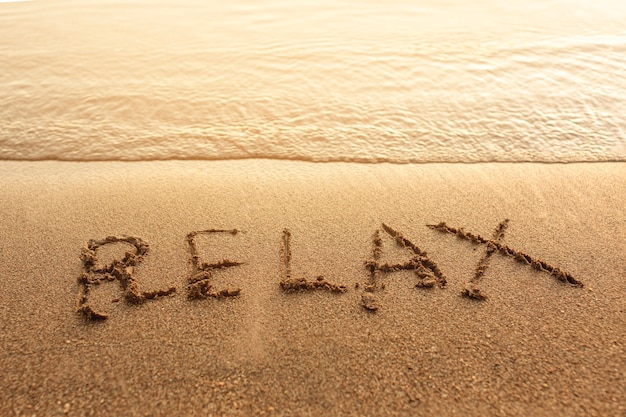 Free photo relax written on sand