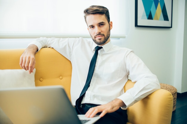 Free photo relaxed businessman sitting on the couch