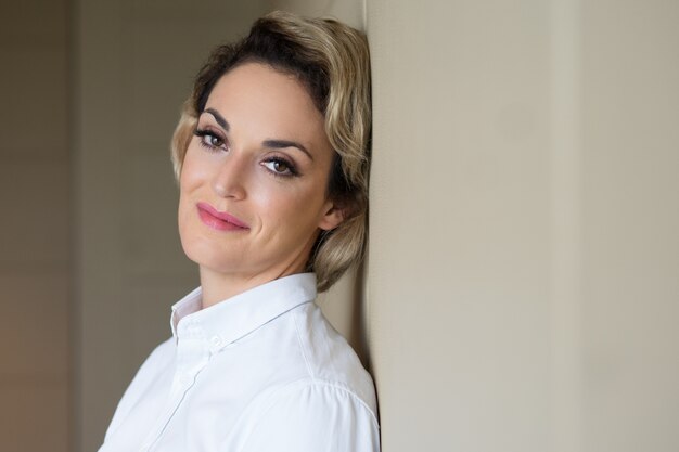 Relaxed Content Middle-aged Woman Leaning on Wall