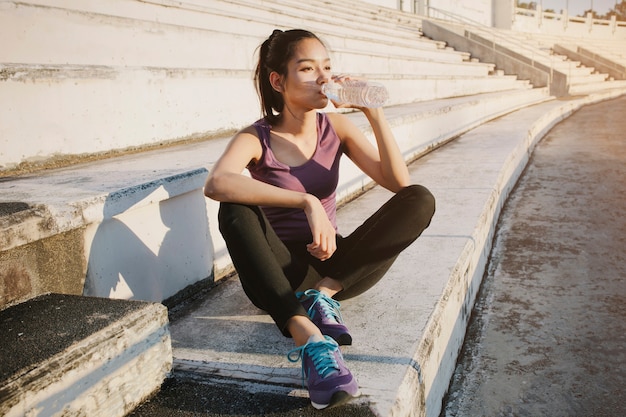 Relaxed girl drinking water outdoors