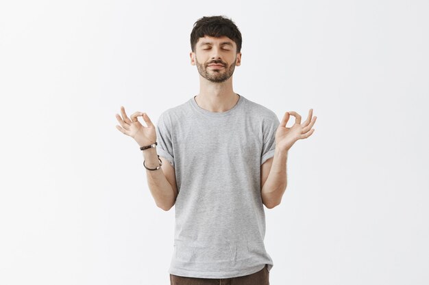 relaxed handsome guy posing against the white wall