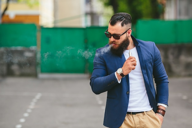 Relaxed man smoking an electronic cigar