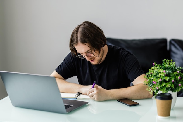 Relaxed man working at contemporary office typing on keyboard sitting on comfy chair