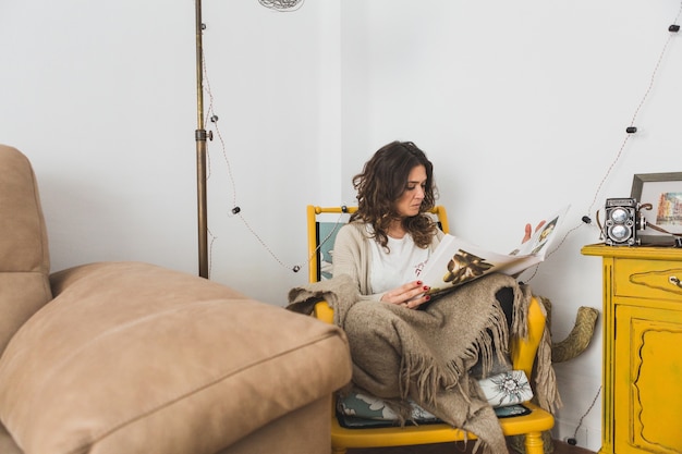 Free photo relaxed woman reading newspaper