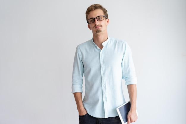 Free Photo relaxed young man holding tablet computer