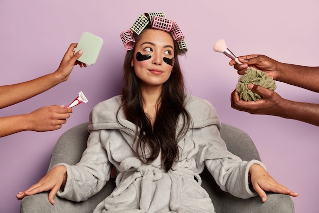 Free Photo relaxed young woman in soft bathrobe, wears cosmetic patches under eyes