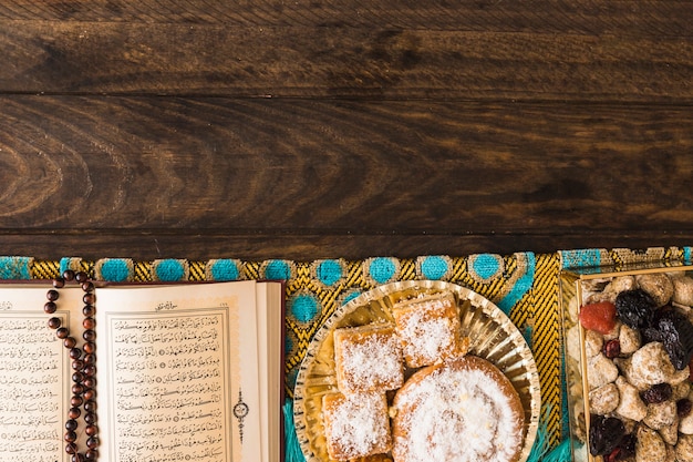 Free photo religious book with beads near arabic sweets