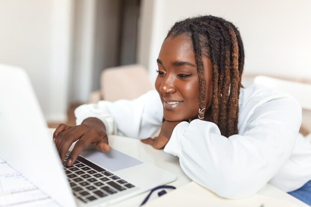 Remote job technology and people concept young African business woman with laptop computer and papers working at home office during the Covid19 health crisis