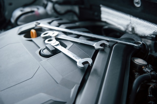 Repair tools lying down on the engine of automobile under the hood