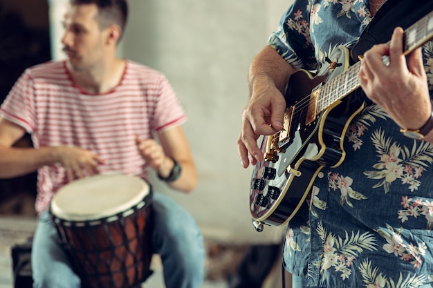 Free Photo repetition of rock music band. bass guitar player, electric guitar player and drummer at loft.