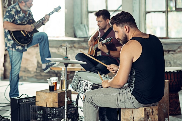 Free Photo repetition of rock music band. electric guitar player and drummer behind the drum set.