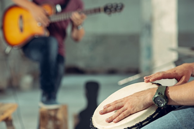 Free Photo repetition of rock music band. electric guitar player and drummer behind the drum set.