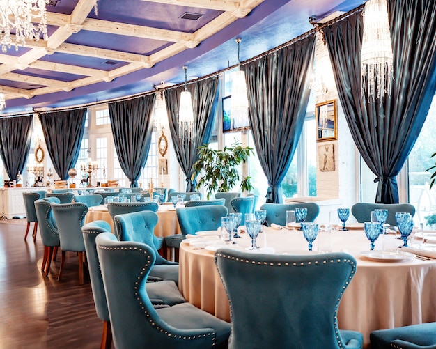 Restaurant hall with blue chairs and blue glasses on the table