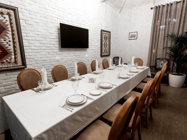 Restaurant private room with white stone walls and brown chairs