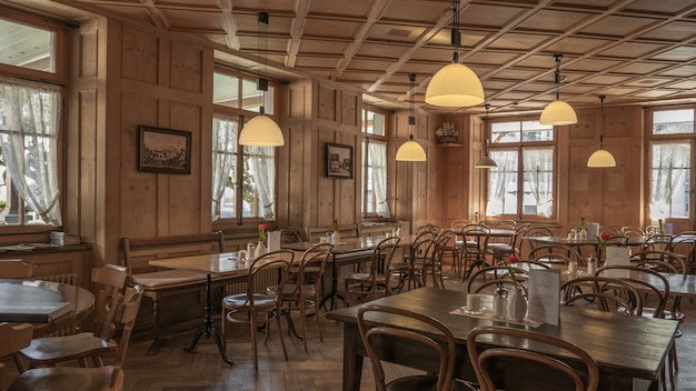 Restaurant setting with wooden chairs and tables and a beautiful view