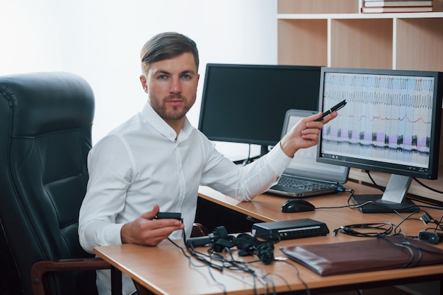 Free Photo resuts will be tomorrow. polygraph examiner works in the office with his lie detector's equipment