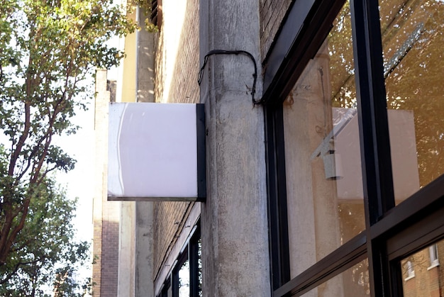 Free photo retail sign with reflection on glass wall and street with trees