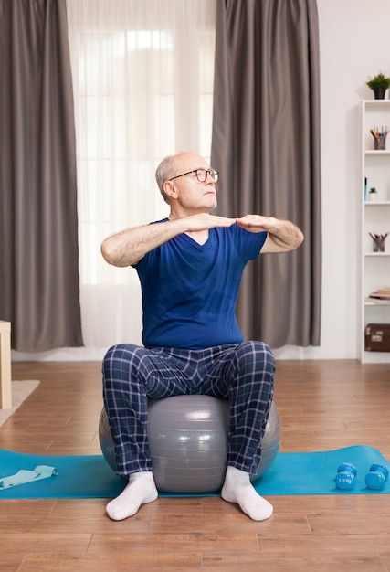 Retired man with healthy lifestyle doing arms exercises