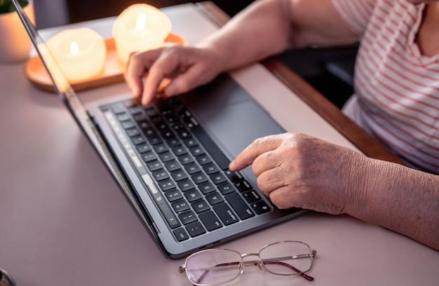 Free photo retired woman uses laptop hands close up