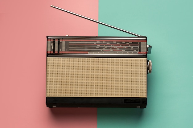 Retro broadcast radio receiver on pink and light blue background