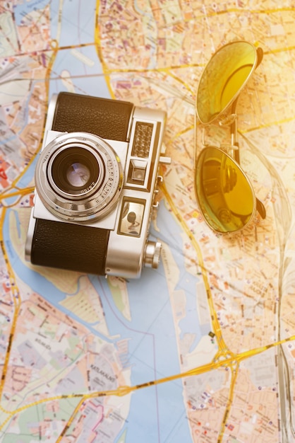 Free photo retro camera and sunglasses on a map