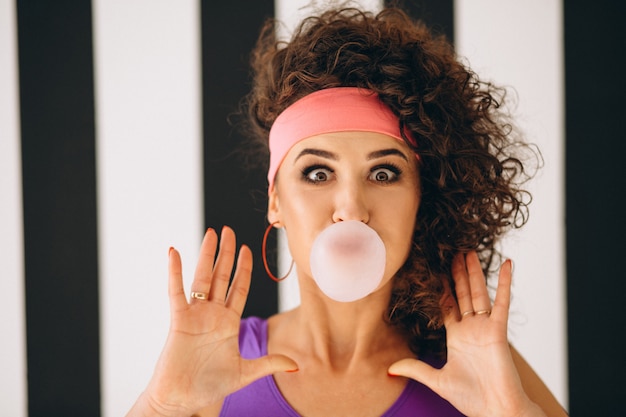 Free photo retro girl blowing bubble with chewing gum