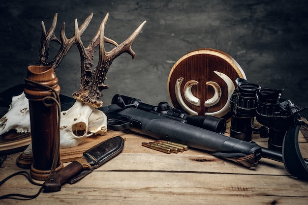 Free photo retro hunting ammunition of rifle and binoculars. delicious sausage and brown bread on a wooden table.