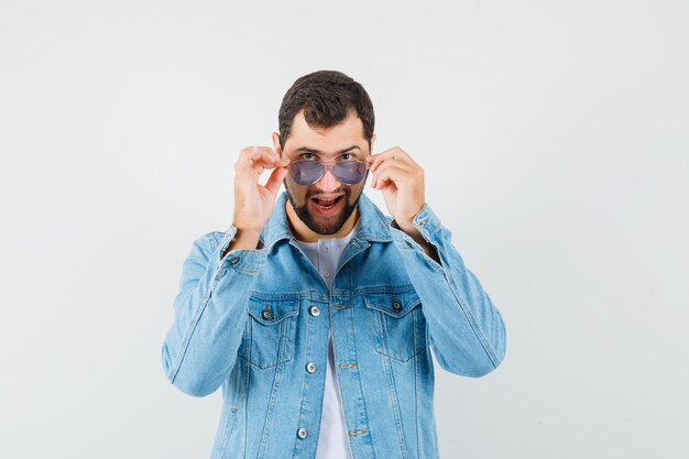 Retro-style man wearing sunglasses in jacket,t-shirt and looking cool. front view.