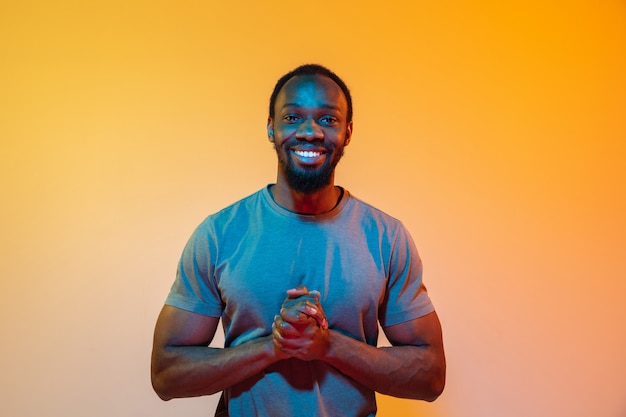 The retro wave or synth wave portrait of a young happy serious african man at studio.