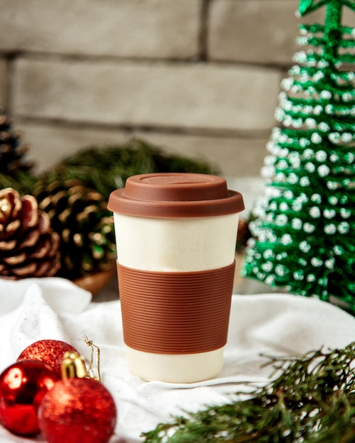 Free photo reusable ceramic coffee cup with brown silicone lid and and sleeve