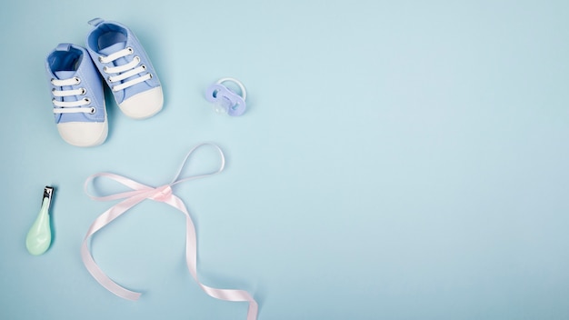 Free photo ribbon with baby shoes copy space