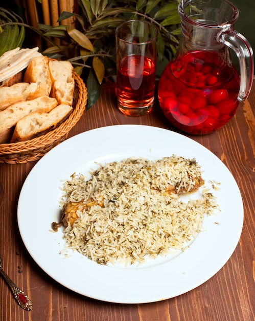 Rice chicken plov with herbs in white plate and composto