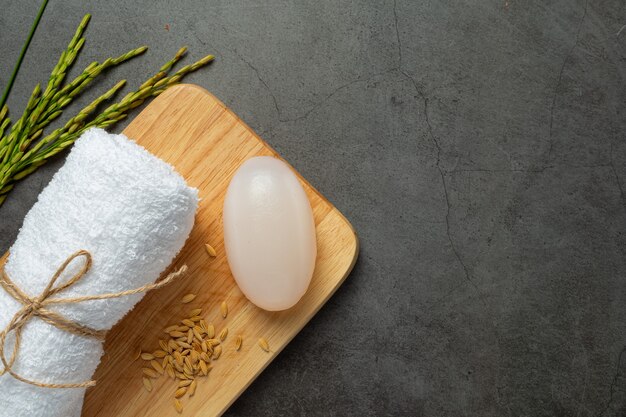 Rice milk soap, rolled towel, rice plants and rice seeds put on wooden try