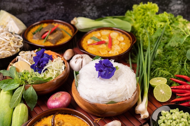 Free Photo rice noodles in a bowl of curry paste with chili, cucumber, long bean, lime, garlic and spring onion