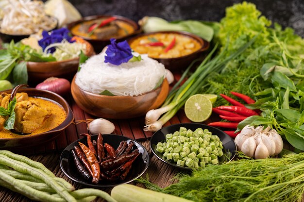 Rice noodles in a bowl of curry paste with chili, cucumber, long bean, lime, garlic and spring onion